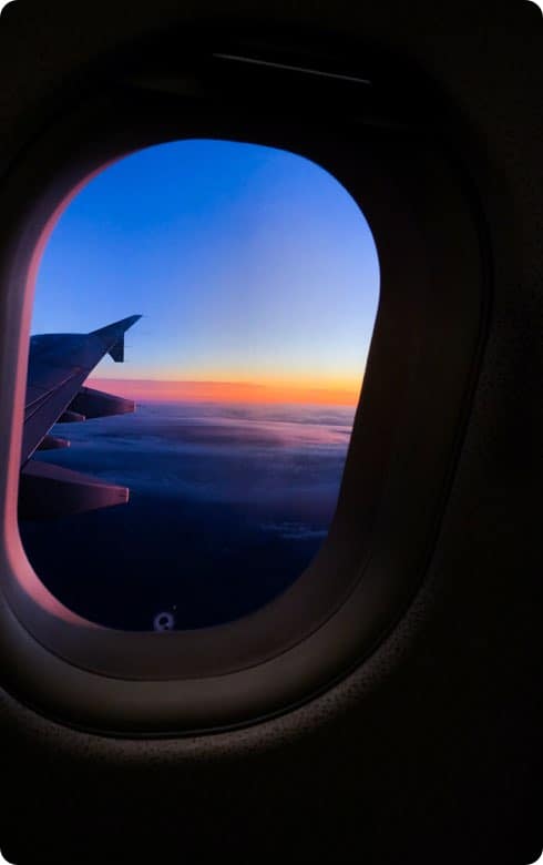 view out an airplane window with the sun rising