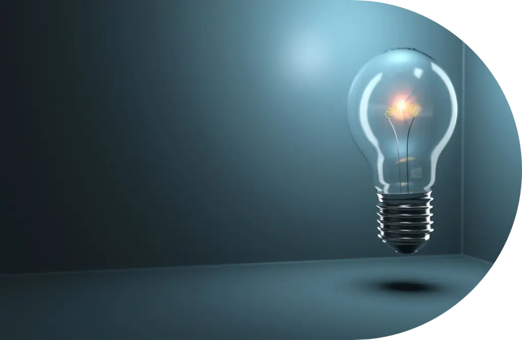 A glowing light bulb floats in a dark, empty room with a soft blue tint, casting a faint shadow on the floor—a quiet nod to innovation in the NZ energy market.